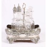 Victorian silver cruet stand of boat form with embossed decoration and later handle containing five