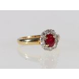 18ct yellow gold ruby and diamond ring with central faceted ruby encircled by ten round cut