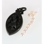 Victorian jet pendant locket with carved fuchsia ornamentation and loose pearls.