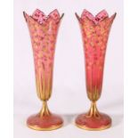 Pair of Venetian cranberry glass vases of trumpet form with gilded foliate spray decoration,