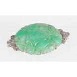 Art Deco style platinum and gold brooch with pierced and carved oval jadeite flanked by eight