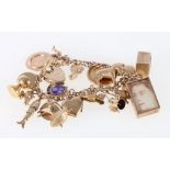 9ct yellow gold charm bracelet with over twenty charms to include Victorian half sovereign 1899,