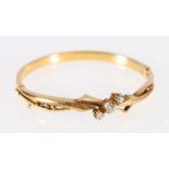 Victorian gold hinged bangle with tree old cut brilliants flanked by angled openwork and engraved