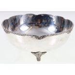 Silver bowl decorated with flowerhead border raised on triple supports, stamped "silver" to base.