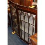 Mahogany serpentine fronted display cabinet raised on ball and claw supports.