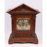 Oak cased mantle clock of architectural form with brass dial, Roman numeral chapter ring,