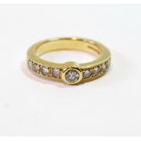 Diamond ring of half eternity style with collet-set brilliant flanked by eight others, in 18ct gold,