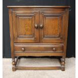 1920s oak two-door cupboard on short baluster supports, 79cm high and 87cm wide.