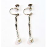 Pair of white gold drop earrings, each with a single pearl upon three links.