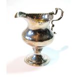 Silver plain baluster cream jug with punch bead edge and scroll handle upon a circular foot,