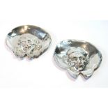 Pair of silver ashtrays, one embossed with the head of a Cleric with bonnet and wide lapels,