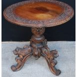 Ceylonese carved wood tripod table with lion carved cabriole legs, 60cm high and 61cm wide.