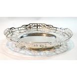 Silver oval shallow fruit dish with scrolling pierced semi-circles and rim on low foot,