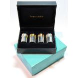 Set of four silver plain cylindrical condiments, two with gilt tops, by Tiffany, 25cm,