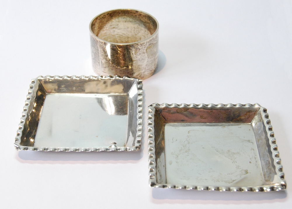 Pair of silver square ashtrays, 1888, and a napkin ring.