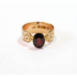 9ct gold engraved band ring with an oval almandine garnet.