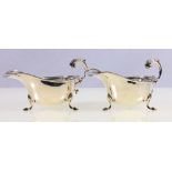 Pair of silver cream boats, with scroll handles, raised on shell cast pad feet, 196g gross, 14.5cm.