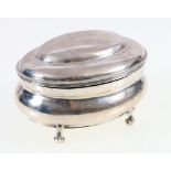 Oval silver box and cover, the hinged cover engraved FGW, raised on scroll feet, London 1907, 161g,