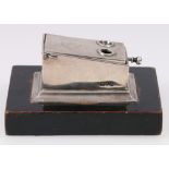 Edwardian silver cigar cutter of rectangular form on ebonised plinth, engraved monogram.