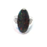 Dress ring with black opal oval doublet flanked by twelve small mixed-cut diamonds, in white gold.