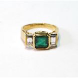 Three-stone ring with rectangular emerald flanked by two baguette diamonds, in 18ct gold.