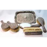 Silver toilet set embossed with scrolls comprising three hair brushes,