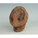 A carved red sandstone head / ornament, possibly medieval, of a grotesque,