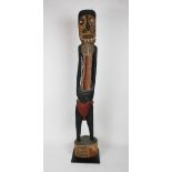 A large Australian carved and painted iron wood ancestral figure, with ohcre surface,