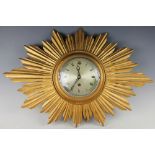 A giltwood sun burst cock, with eight day movement and Roman numeral dial,