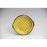 A miniature slipware dish 18th/19th century, of circular form glazed in ochre with brown lined rim,