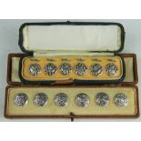 A cased set of six silver buttons, Levi and Salaman, Birmingham 1904, cast with an exotic bird,