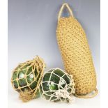 A pair of green glass floats surrounded by hatched rope along with a boat fender (3)