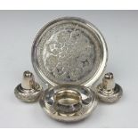 A Persian white metal condiment set, comprising a circular tray, two pepperettes and a salt,