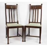 A pair of Art Nouveau oak chairs, each blue tartan upholstered seat below a motif pierced splat,