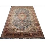 An Indian wool carpet, worked with an all over foliate design against a blue ground,