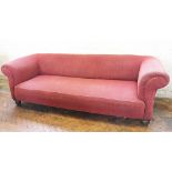 An Edwardian Chesterfield type settee, with textured red upholstery, on bun feet,