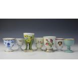 A collection of six continental porcelain egg cups, comprising,