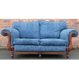A modern two seater salon scroll end settee, with floral blue upholstery, on turned legs,