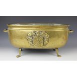 A late 19th century brass jardiniere, of oval shape with two solid handles, cast with coat of arms,