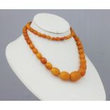 An amber bead necklace, strung with sixty six graduated beads (9mm - 2.4mm wide), 51.
