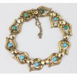 A turquoise set bracelet, designed as ten wing shaped links, each centred by a turquoise cabochon,