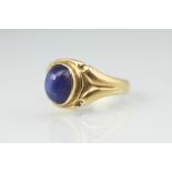 A synthetic star sapphire set ring, the oval cabochon stone within rub-over collect setting,