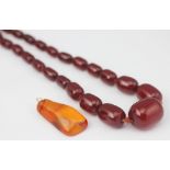 A cloudy red amber coloured bead necklace,
