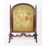 A Victorian carved walnut fire screen, with tapestry insert and barley twist sides, on scroll legs,