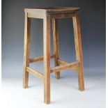An oak stool, the solid top square seat raised above four block legs and stretchers,