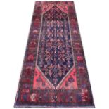 A Caucasian wool runner, worked with an all-over foliate design against an abrashed blue ground,