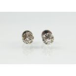 A pair of diamond set stud earrings, each claw set in white metal, unmarked, gross weight 1.