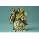 A 19th century Japanese ivory netsuke, carved depicting a man in Jifu holding a turtle,