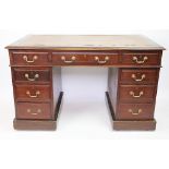 An Edwardian mahogany pedestal desk, with an arrangement of nine drawers, on plinth base,