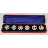 A set of six Edwardian silver buttons, each cast and pierced with a floral garland,